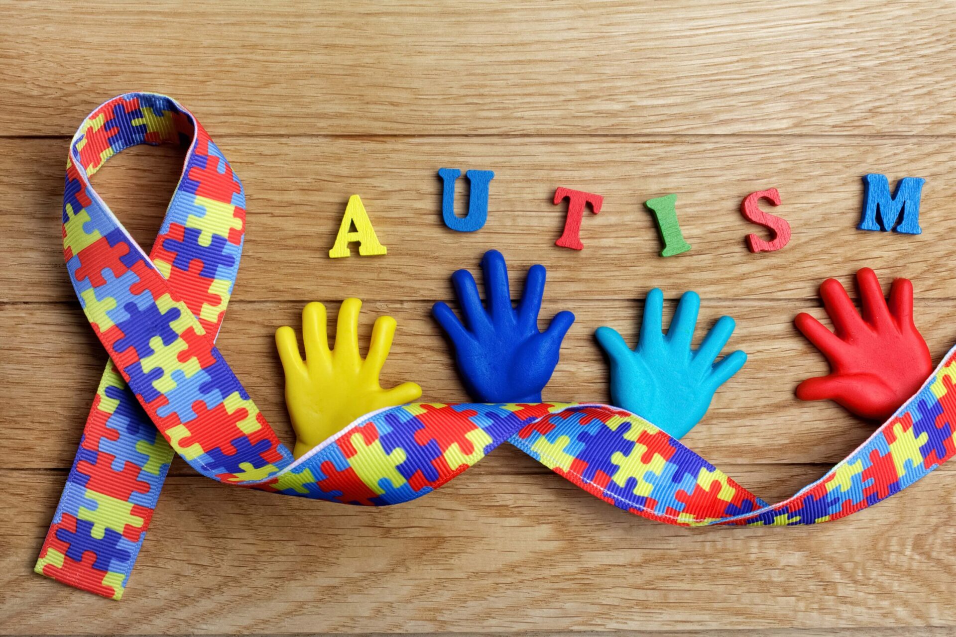 Autism,Awareness,Concept,With,Colorful,Hands,On,Wooden,Background.,Top